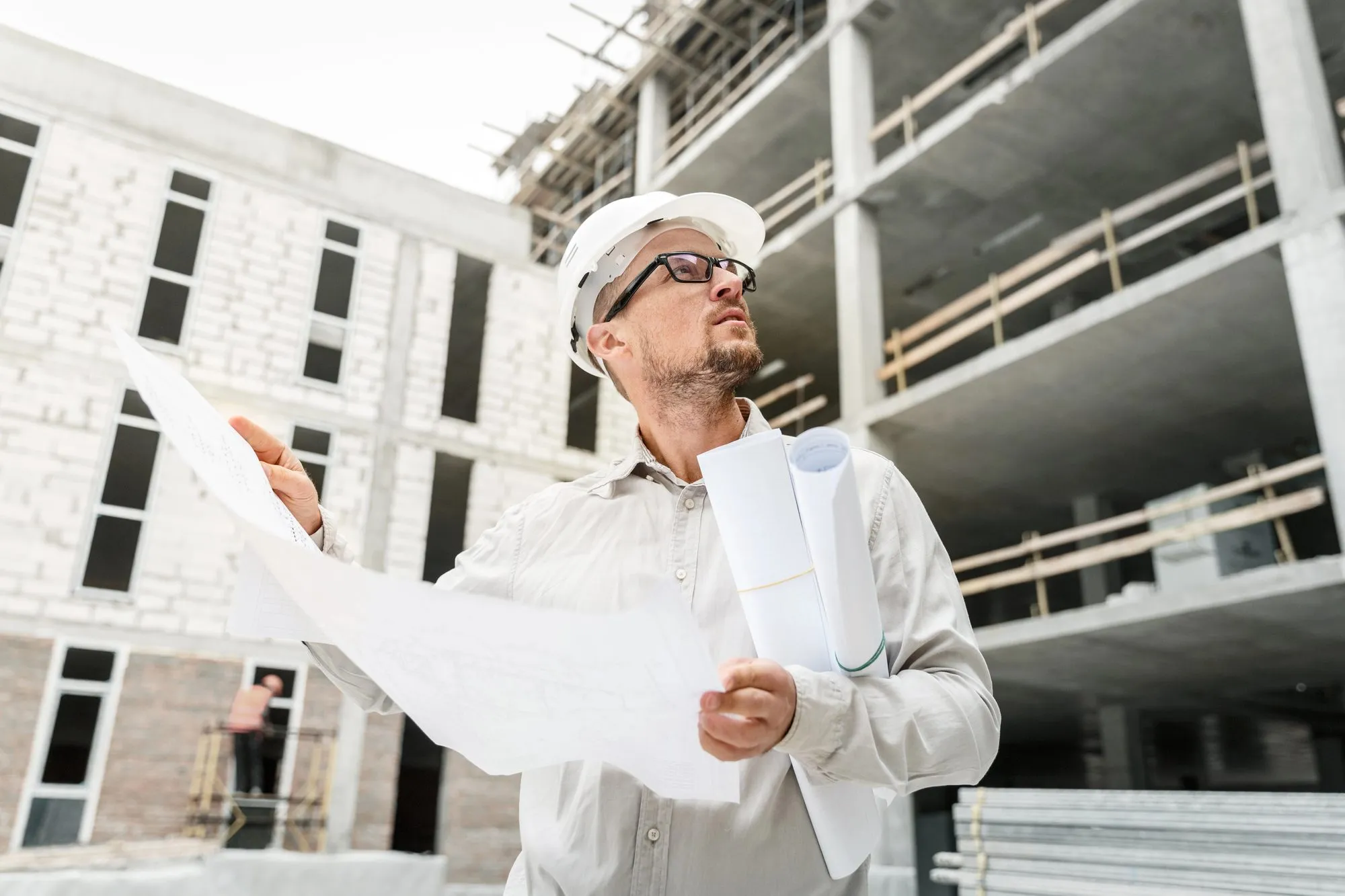 Specialist reviewing building plans at a commercial project site